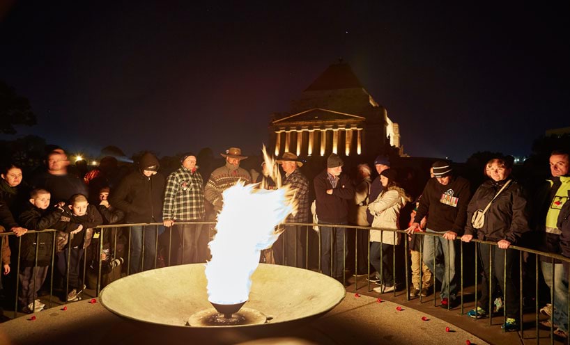 People standing around the memorial on ANZAC Day at dawn